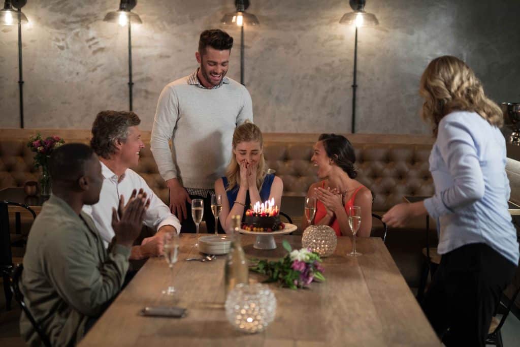 woman receiving surprise birthday cake from her fr 2023 11 27 04 58 56 utc 1